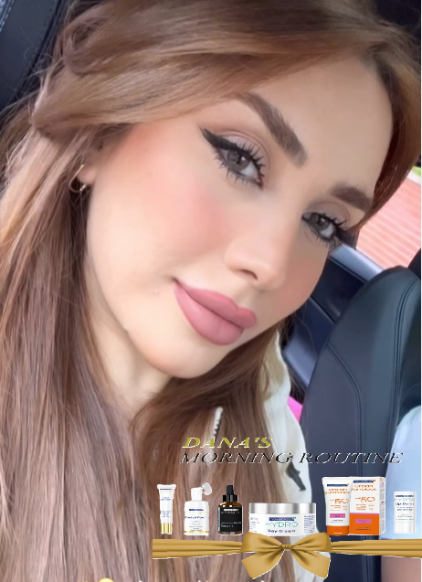 A close-up selfie of a woman with long light brown hair wearing a white top, seated in a car. Overlaid at the bottom is a promotional graphic titled 'DANA'S MORNING ROUTINE' with several skincare product bottles and tubes arranged on a gold banner.